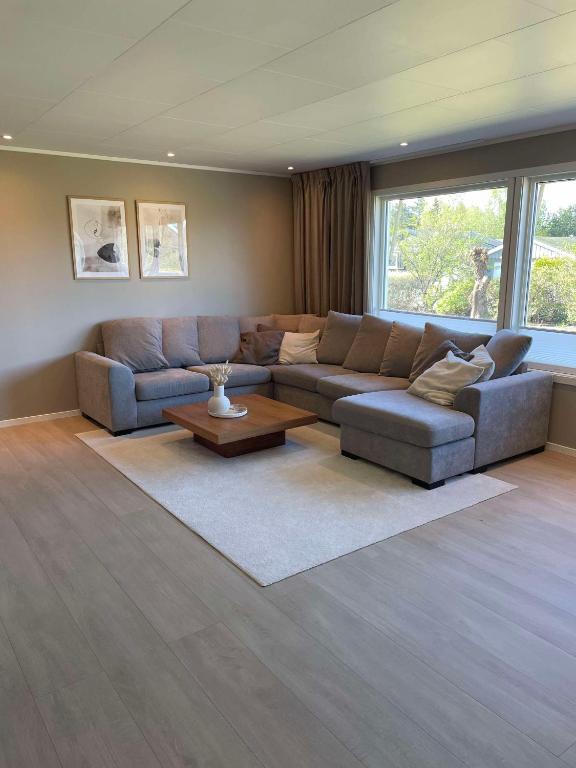 a living room with a couch and a table at Modern 3 bedroom villa 10min from Oslo Airport Gardermoen in Jessheim