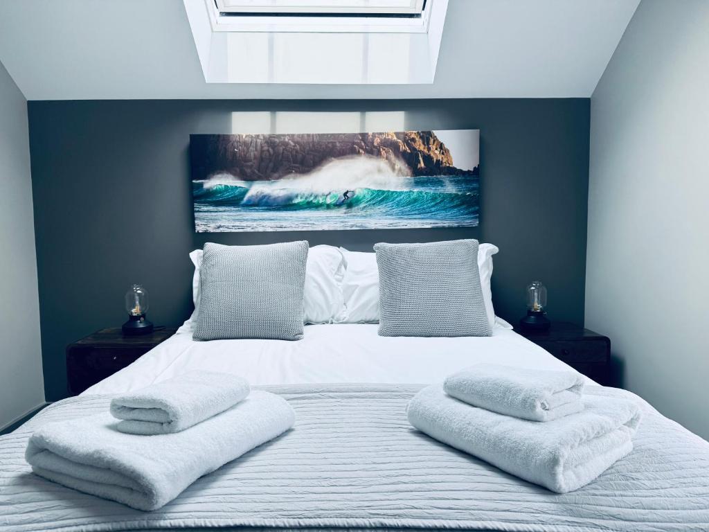 特鲁罗Uno in the City - Luxury Serviced Accommodation的一间卧室，有一张大床，床上有两条毛巾