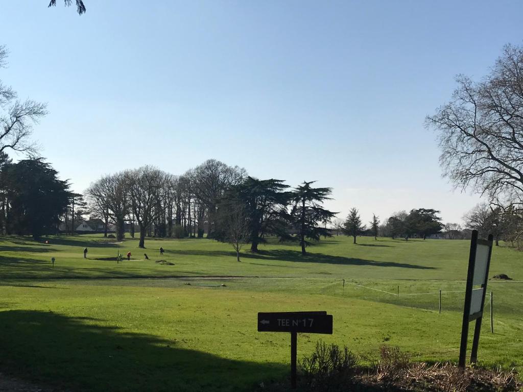 un parc avec un panneau au milieu d'un champ dans l'établissement Manoir de l'Herbier, à Saint-Sulpice