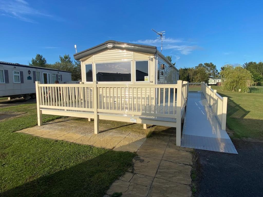 a large white deck with a gazebo at Oak Village 64 - Grange Leisure disability caravan - pet friendly, wifi and ramped decking in Mablethorpe