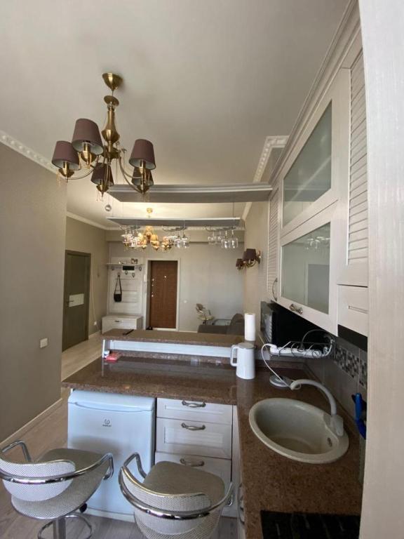 a bathroom with two chairs and a sink and a bed at Студия in Bishkek