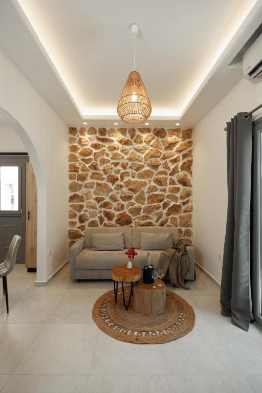 a living room with a couch and a stone wall at CasaNova Luxury Apartment in Naxos Chora