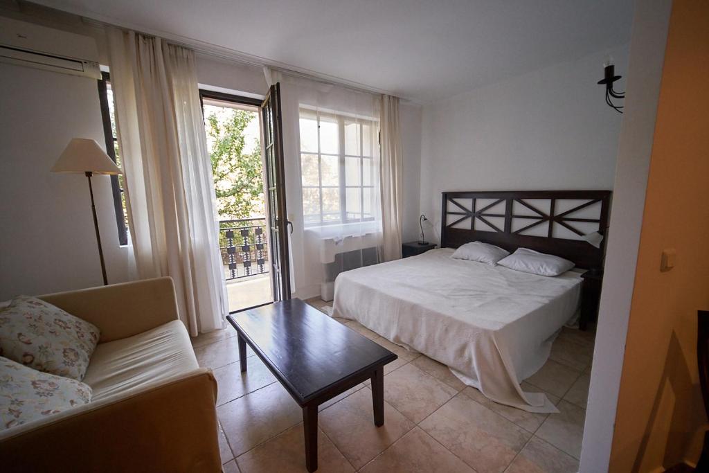 ein Schlafzimmer mit einem Bett, einer Couch und einem Tisch in der Unterkunft The Cliff Lux Apartment Obzor, Burgas, Bulgaria in Obsor