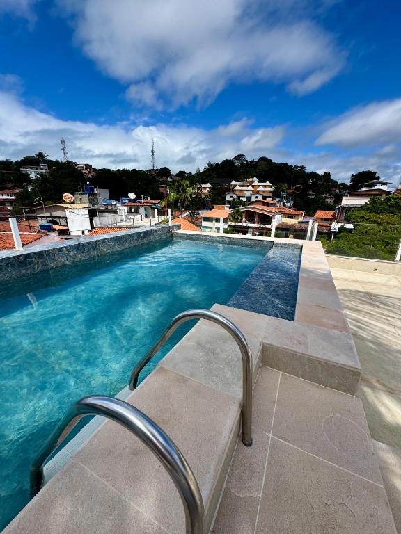 a bench sitting next to a swimming pool at Piratas Do Morro Apartamento Praça in Morro de São Paulo