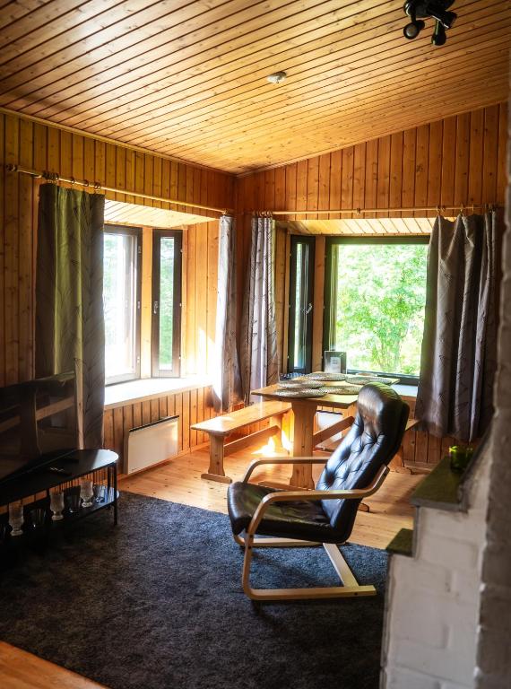 a living room with a chair and a table at Villa Christmas Star Private Sauna By Lapland Host in Rovaniemi
