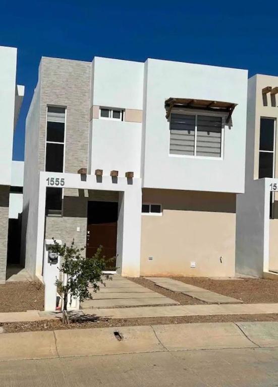 a white building with a door and a window at Almarena Residencial in Mazatlán