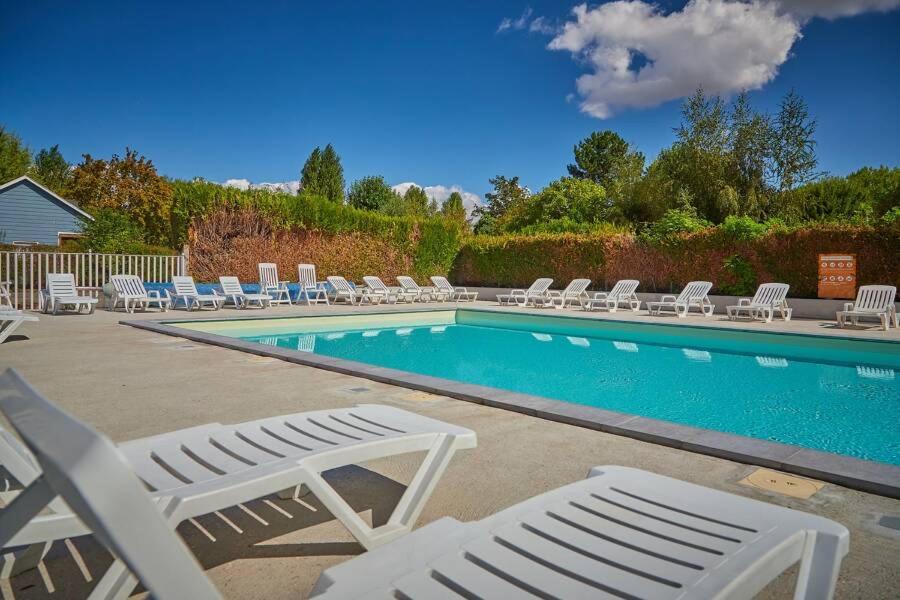 a swimming pool with lounge chairs and a swimming pool at Mobilhome in Ivry-la-Bataille