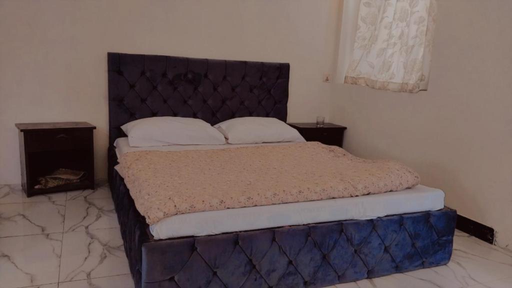 a bedroom with a bed with a blue headboard at Junction Resort 