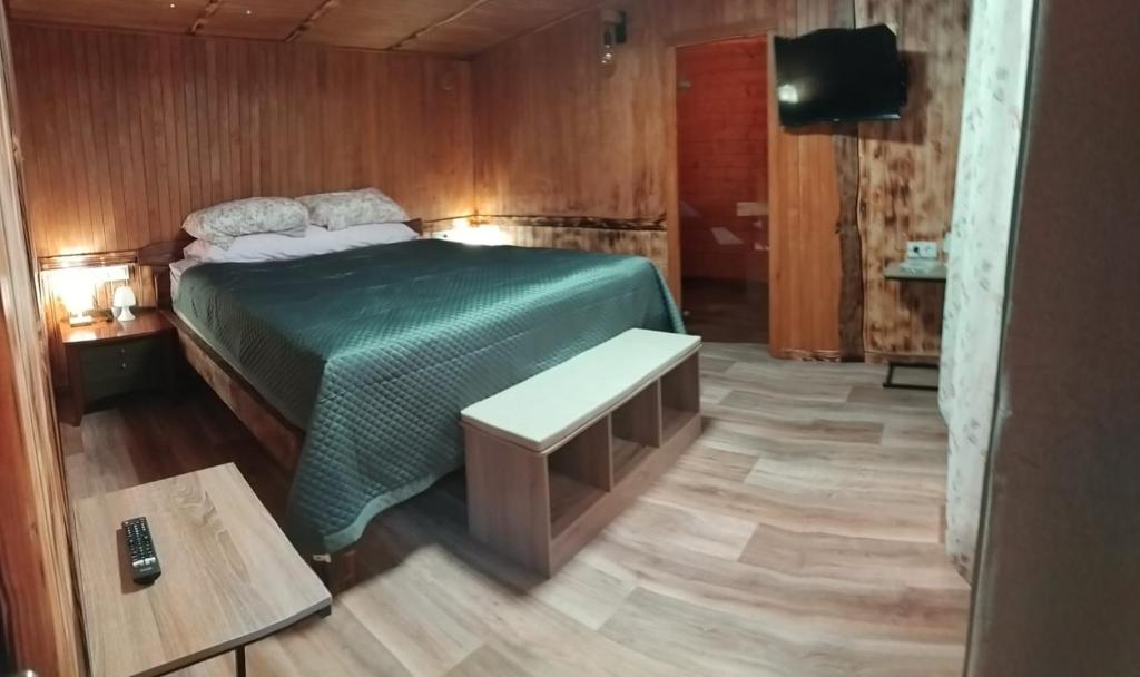 a bedroom with a green bed and a bench at Oasis rural in Benidorm in Benidorm