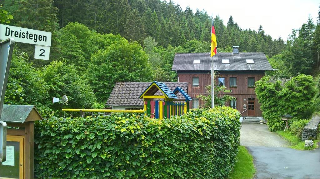 a house with a flag on top of a hedge at Ferienhaus Königreich - Dreistegen in Monschau