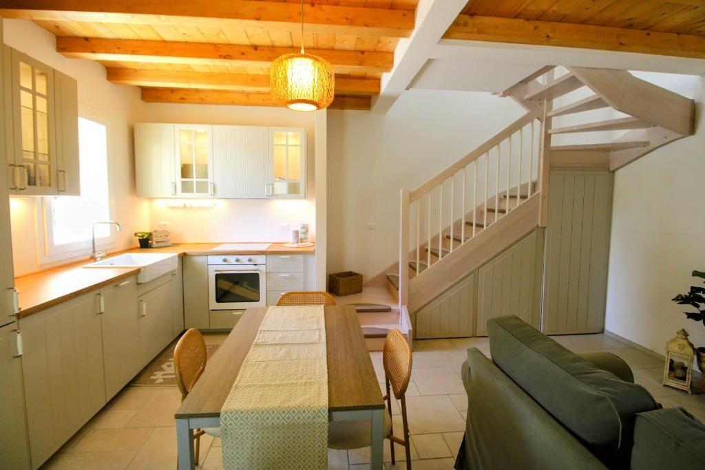Una cocina y un comedor con una mesa y una escalera. en Nasica Green, en Castenaso