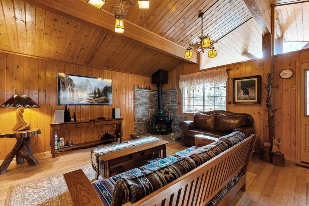 Una sala de estar con un sofá de cuero y una mesa. en Craftsman Hideaway ~ Cabin near the lake and zoo with fireplace, full kitchen, patio, & BBQ, en Big Bear Lake
