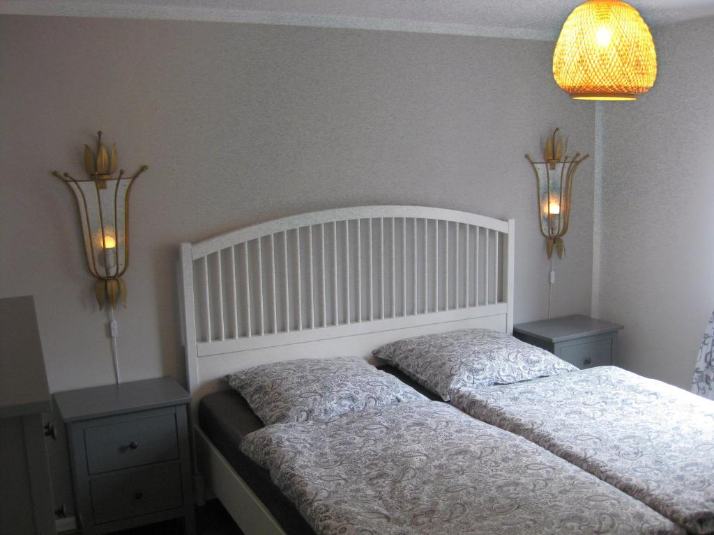 a bedroom with two beds and two lights on the wall at Ferienwohnung Alte Schmiede in Herbolzheim