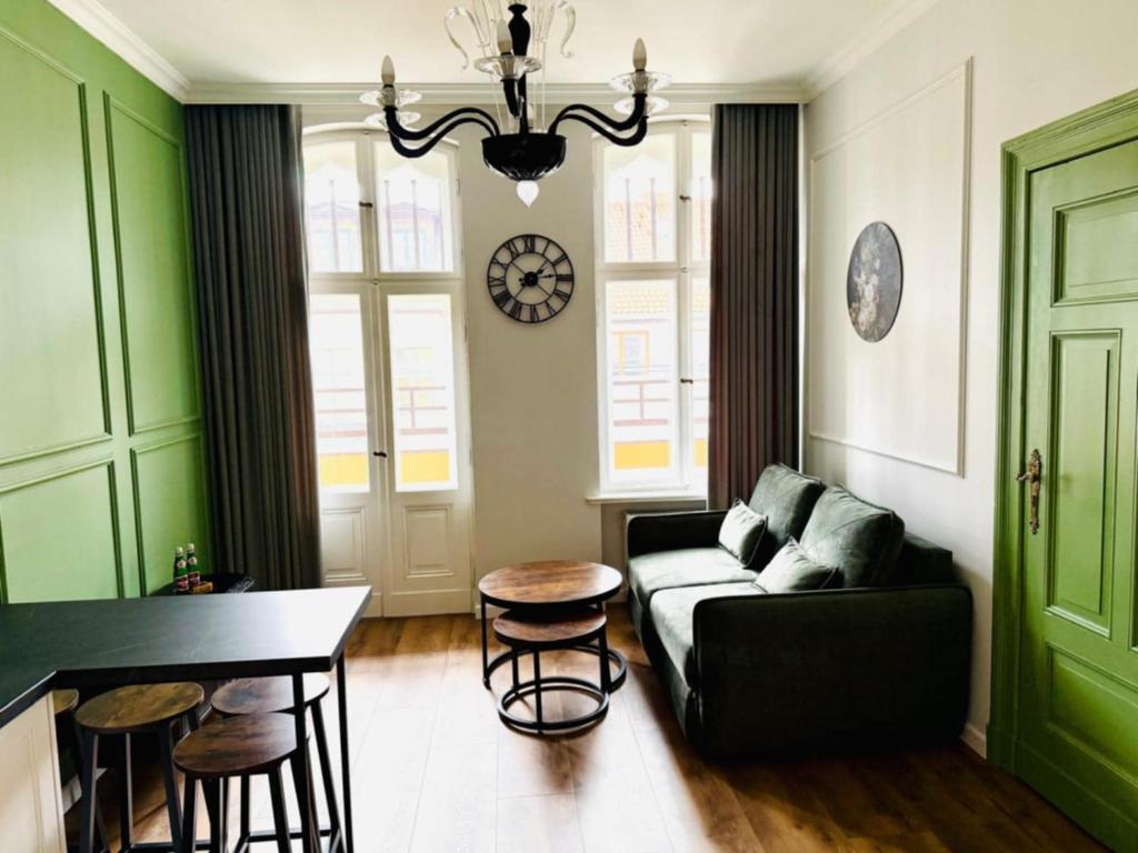 una sala de estar con un sofá y una mesa en Belvedere Old Town with Balcony AC Progres, en Toruń