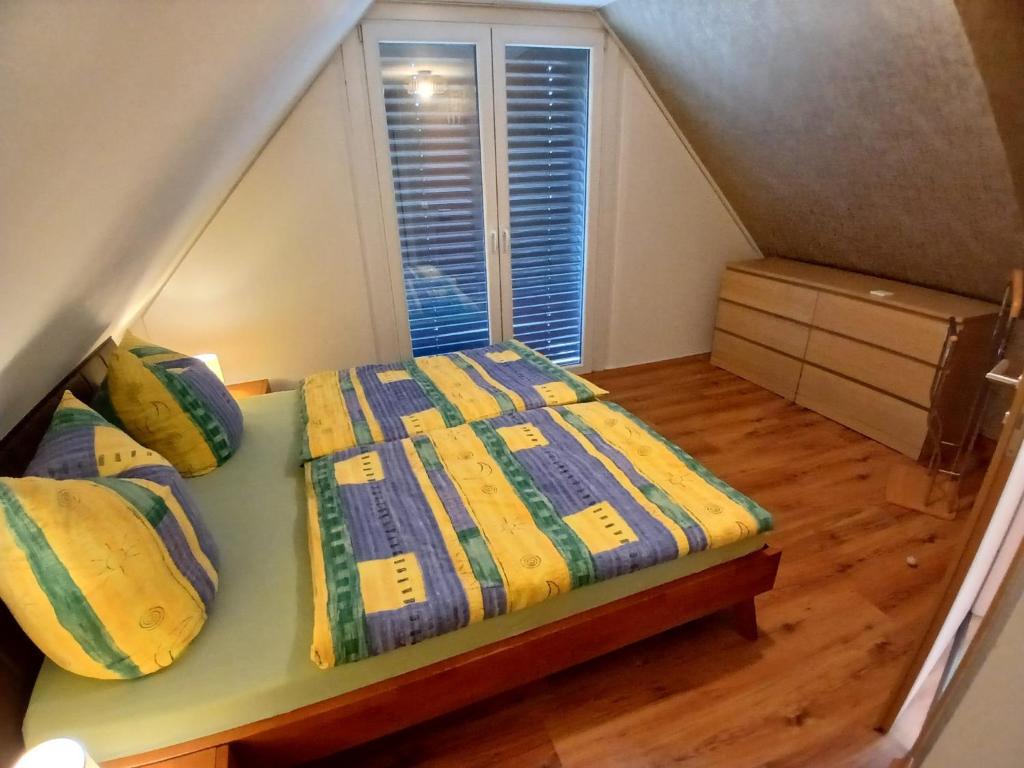 1 dormitorio con 1 cama con edredón amarillo y azul en Bungalow in Kühlungsborn, en Kühlungsborn