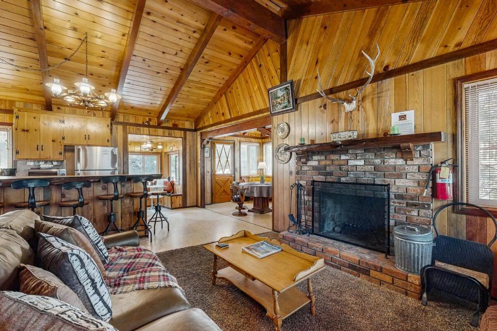 sala de estar con chimenea y cocina en Idle Ours Cabin ~ Rustic and Cozy Cabin with Fireplace & Private BBQ - Walk to Big Bear Lake, en Fawnskin