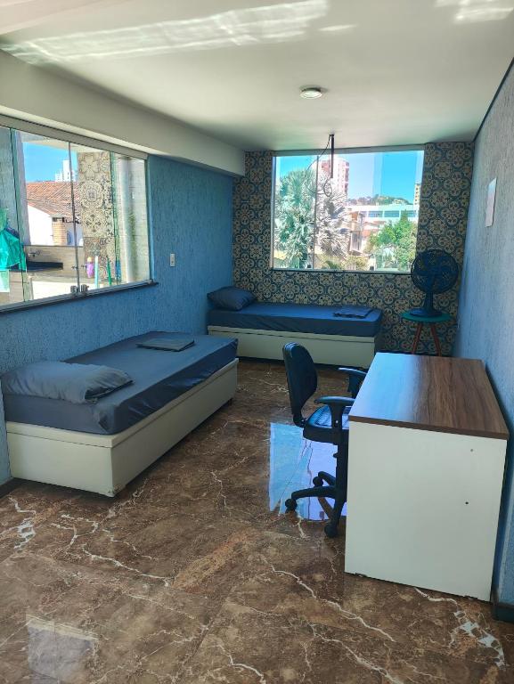 a room with a bed and a desk and a desk at Cobertura Pampulha in Belo Horizonte