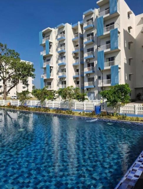 a large swimming pool in front of a building at UrbanEdge Negombo Resort Apartment in Negombo