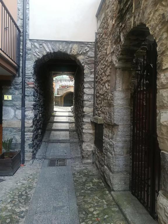 a stone building with an archway and a brick wall at casa Nada in Gera Lario