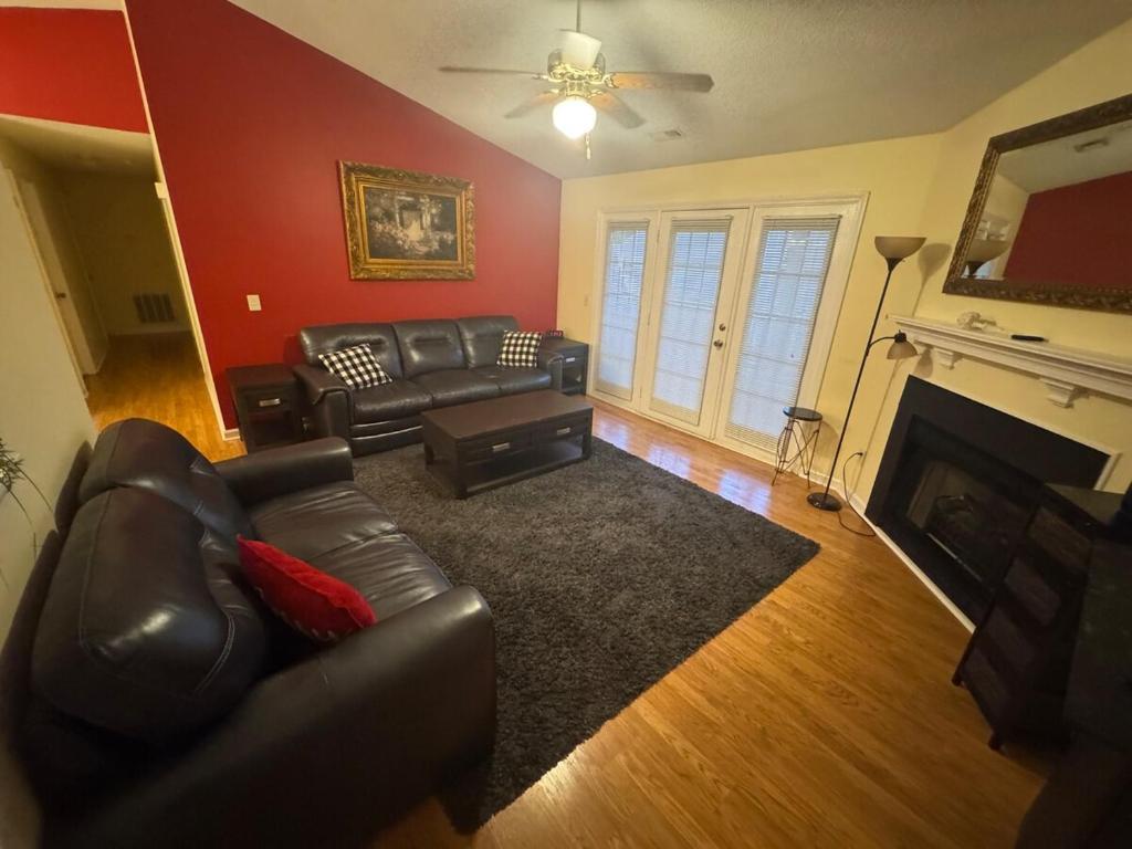 a living room with a leather couch and a fireplace at 2Bed 2Bath Cozy Apartment off Guilford college! in Greensboro