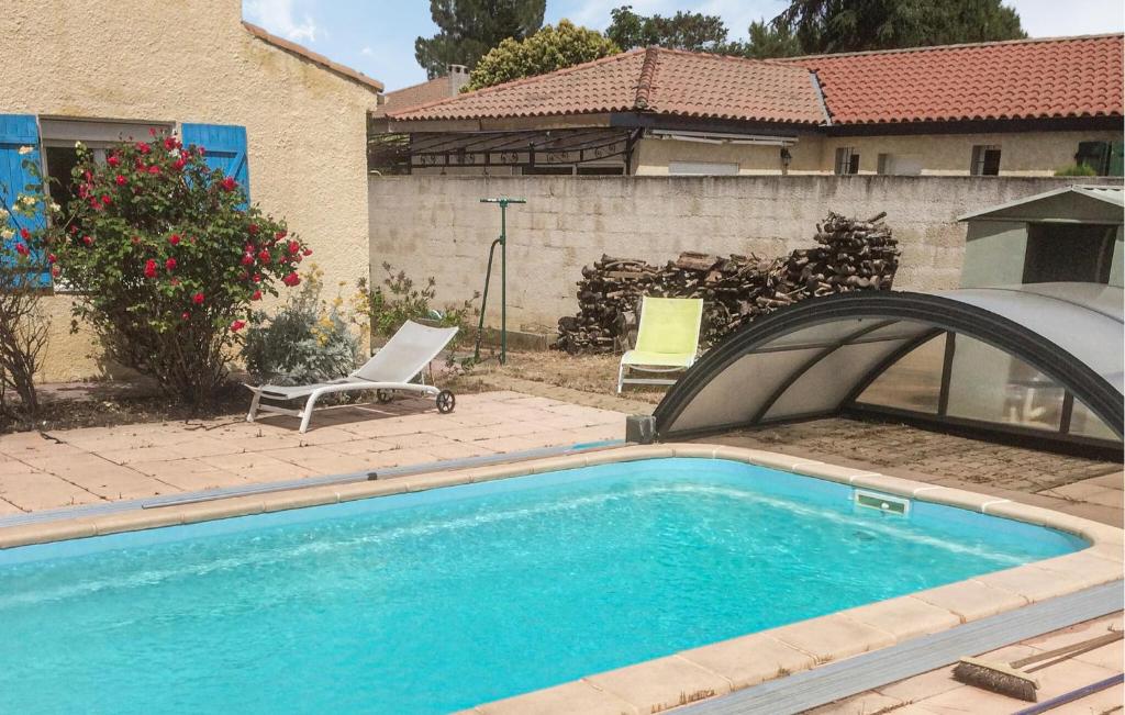 a swimming pool with two chairs next to a house at Stunning Home In Bassan With Wifi in Bassan