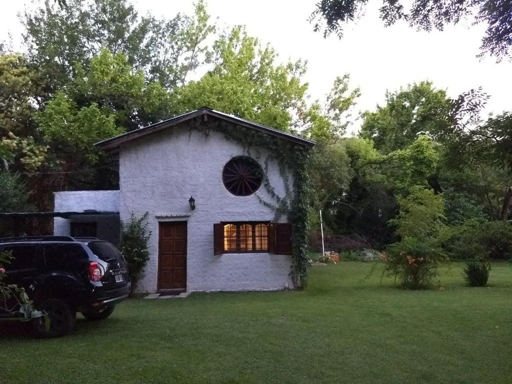 ein weißes Haus mit einem Fenster in einem Hof in der Unterkunft Casita confortable rodeada de Naturaleza in La Cumbre