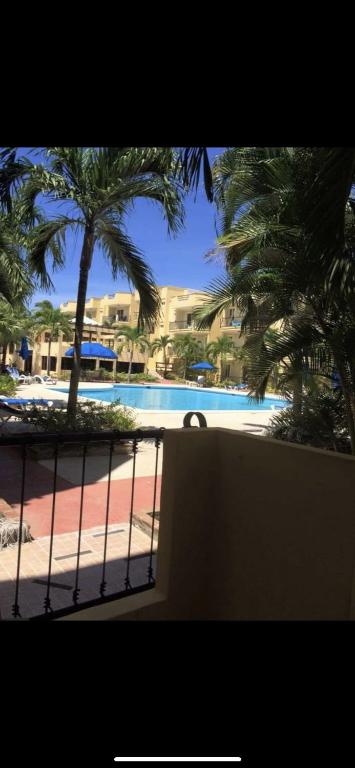 a view of a swimming pool with palm trees at Garden condos, unit#8 in Sosúa