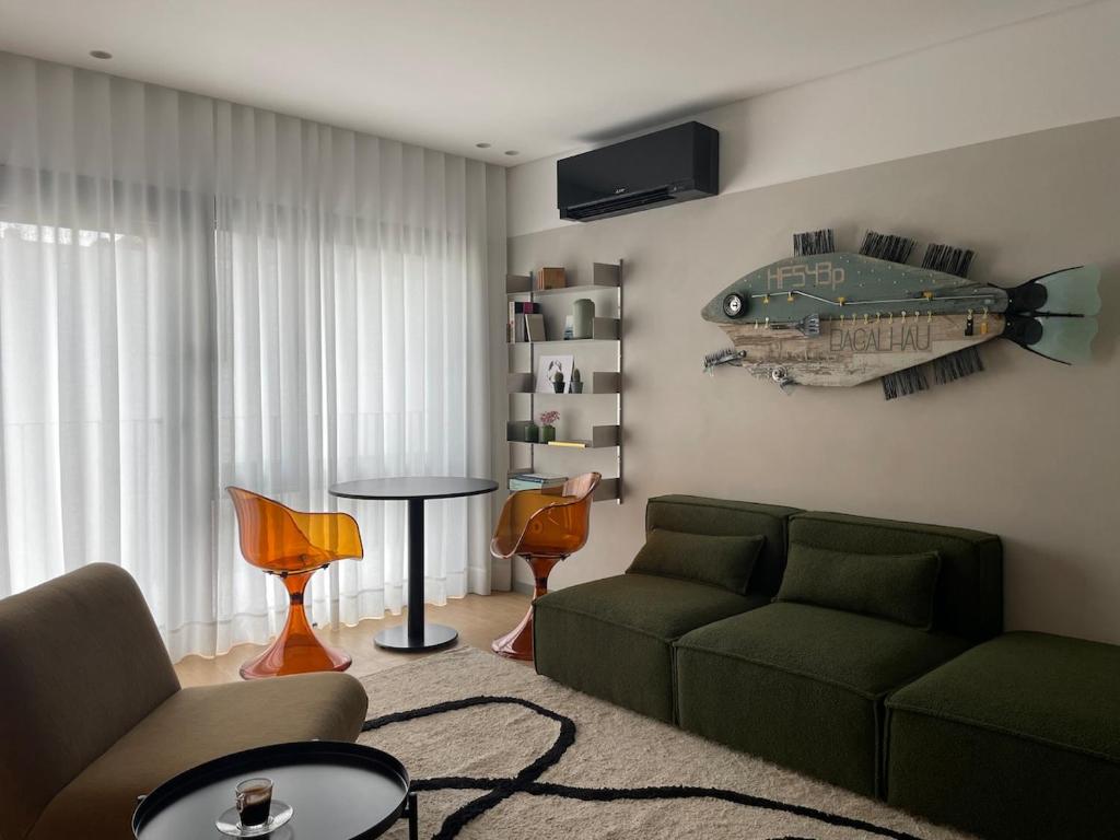 a living room with a couch and a fish on the wall at Green & Grey Loft in Matosinhos