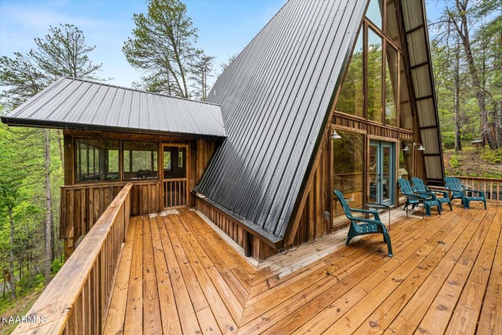 a cabin with a metal roof on a wooden deck at Smoky Mtn A-Frame Retreat, Swim Spa & Game Room in Sevierville