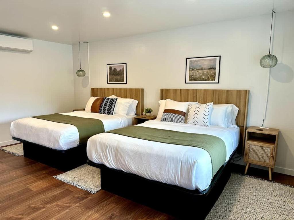 two beds in a room with wood floors at Columbia Cabins Cabin 9 in Sonora