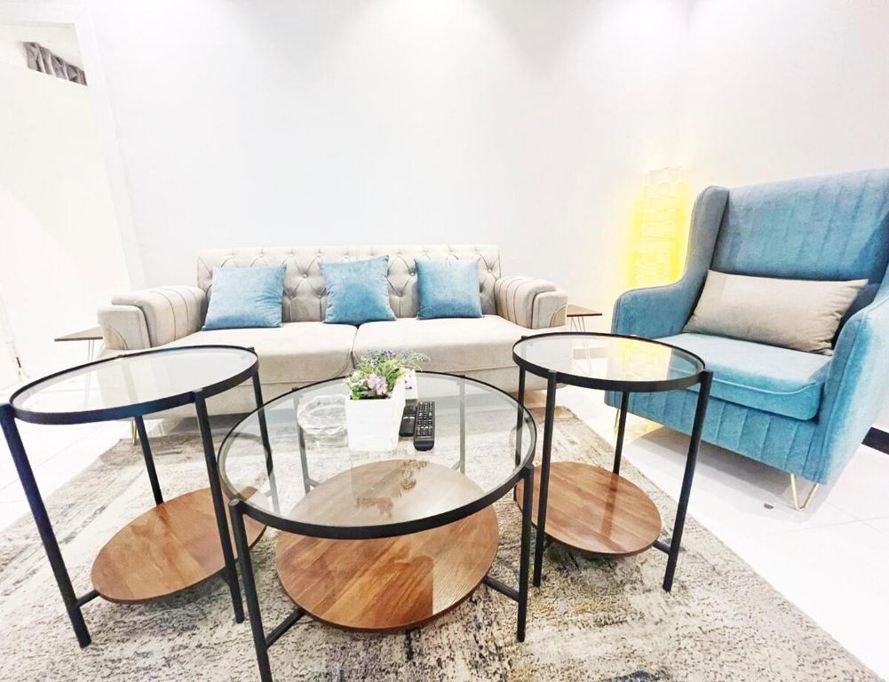 een woonkamer met 2 tafels en een bank bij Boulevard Apartment-H1 in Riyad