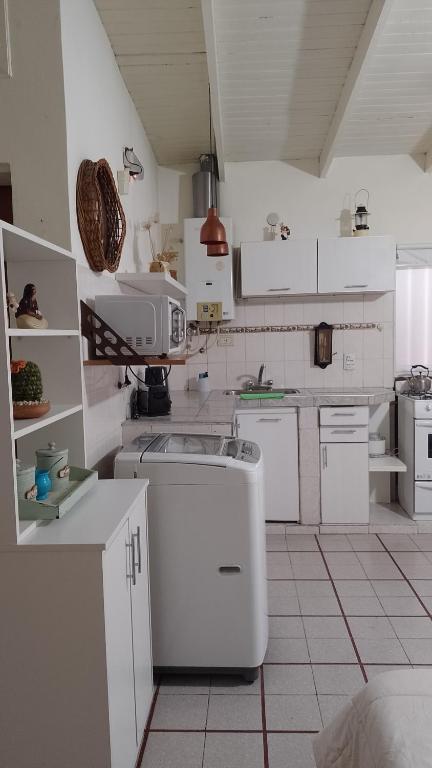 内乌肯Monoambiente Osvaldo的一间白色的大厨房,配有白色的橱柜和电器