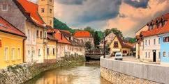 a painting of a town with a river and buildings at Apartments Paradiso in Samobor