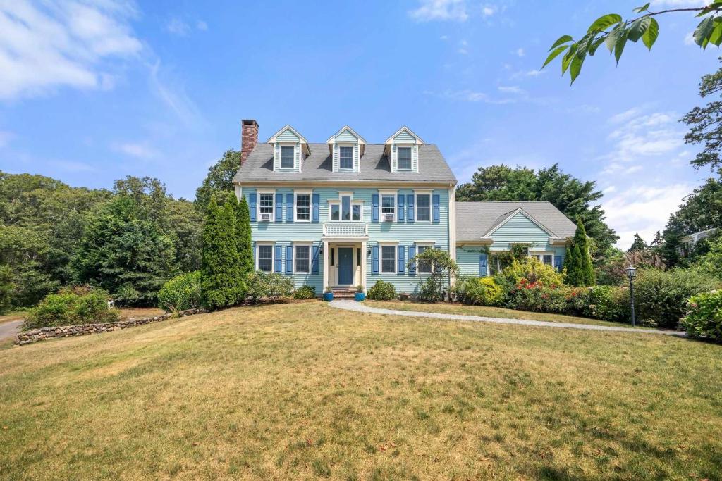 una gran casa azul con un gran patio en Classic Cape Walk to Red River Beach, en Harwich