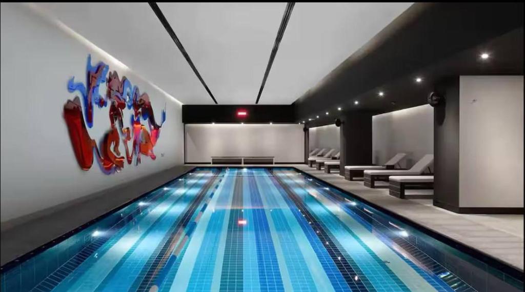 a large swimming pool in a room with chairs and a table at Modern 2BR Deal Prime Spot in Istanbul