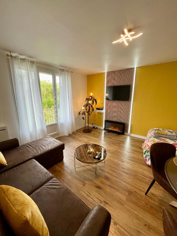 a living room with a couch and a table at Le SOLEIL D OR à 10 minutes de Nigloland in Bar-sur-Aube