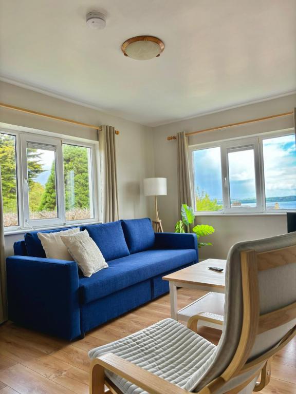 a blue couch in a living room with windows at Cathedrals Corner Cobh in Cobh