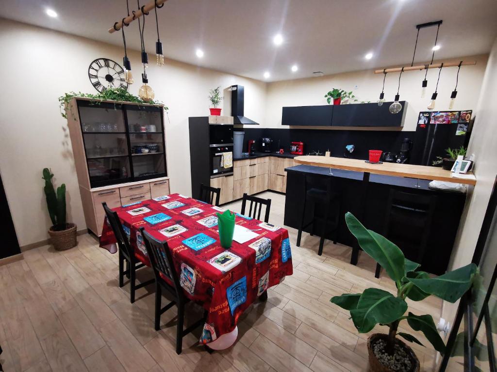 eine Küche mit einem Tisch mit Stühlen und einer Theke in der Unterkunft Maison de village sur 2 étage in Saint-Gilles