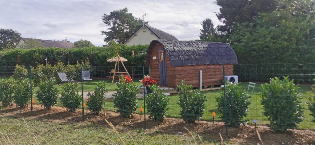 a garden with trees and a barn in the background at Cahute enchantée Aubois dormant in Magny-Fouchard