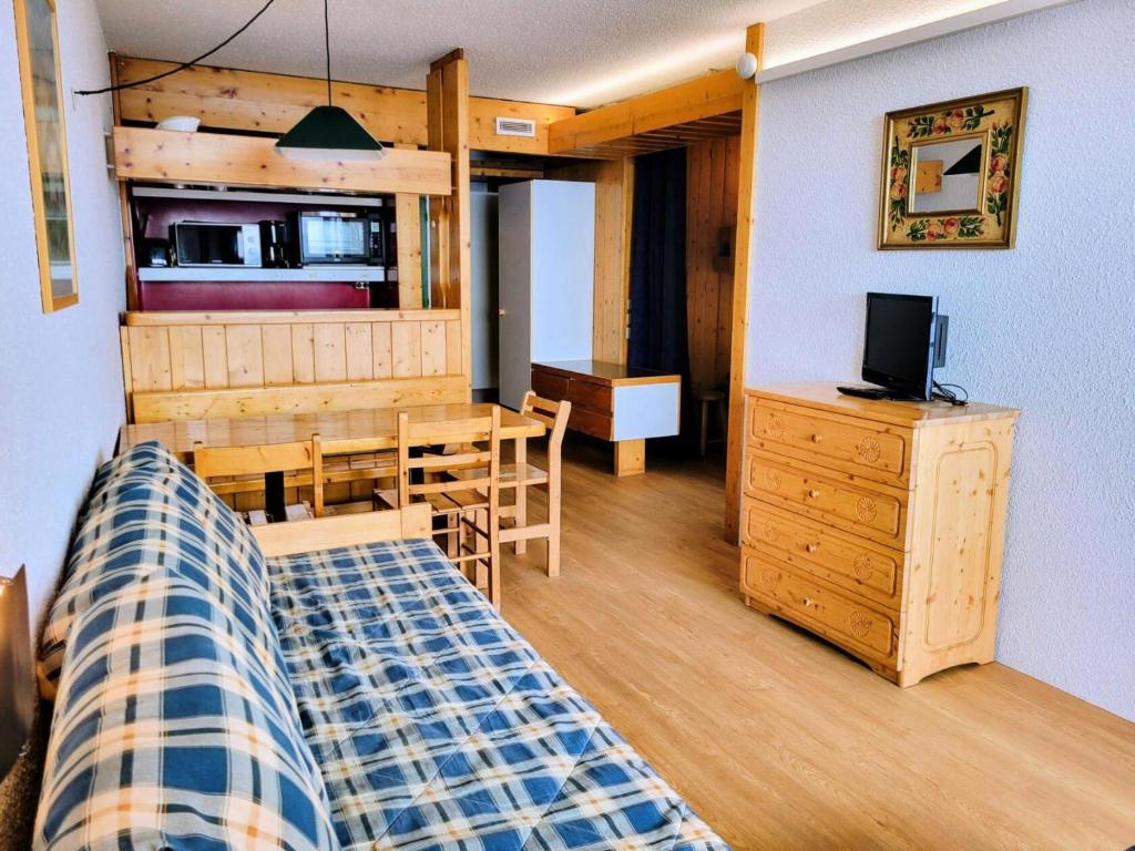 a room with a bed and a table and a television at Résidence Nova 3 - Appartement 2 pièces 6 personnes proche des pistes MAE-8014 in Arc 1800