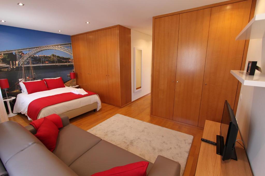ポルトにあるBRA.com Apartments Oporto Bonfimのベッドルーム(ベッド1台、ソファ、テレビ付)