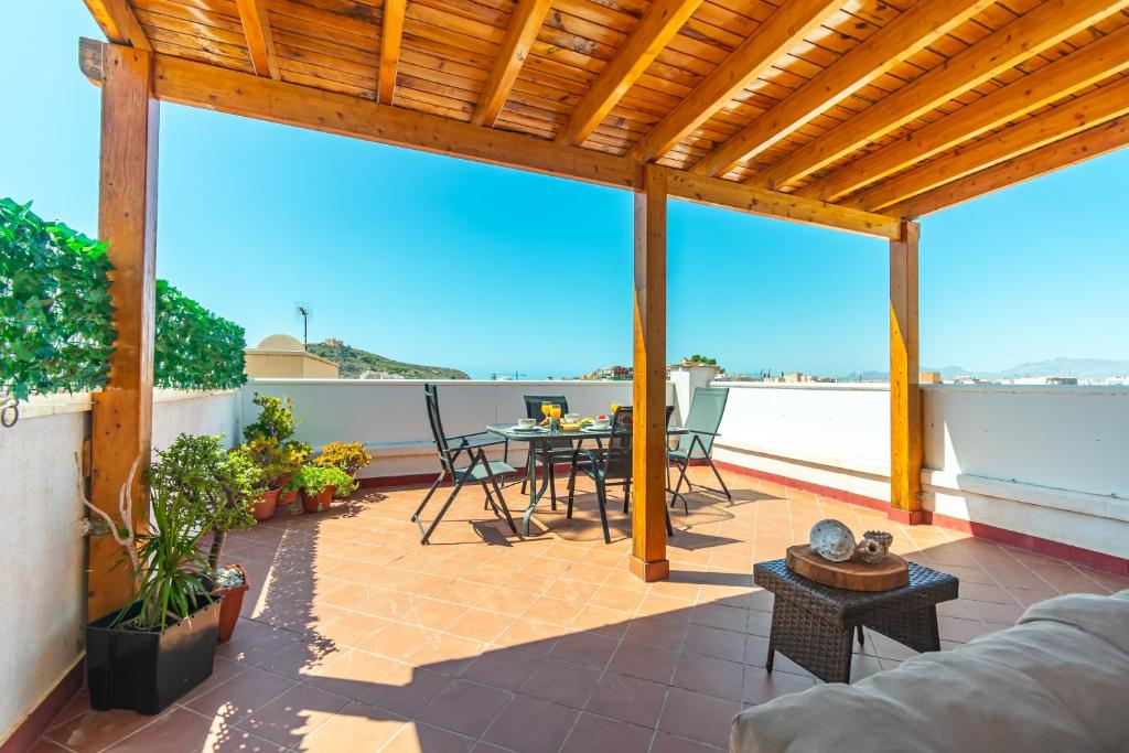 a patio with a table and chairs on a roof at La Azotea - By Aloha Palma in Águilas