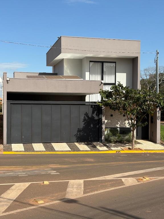 a building on a street with a garage at Casa Premium Adamantina in Adamantina