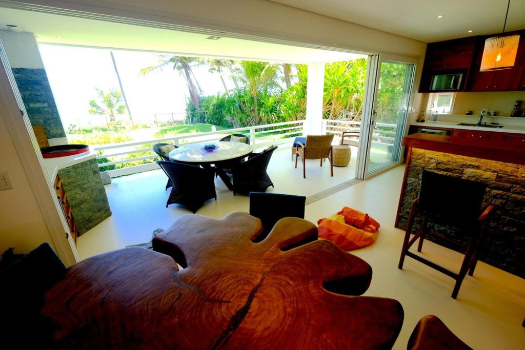 マタ・デ・サン・ジョアンにあるBeach Front Luxury, Praia do Forte, Feet in the Sand!のテーブルと暖炉のあるリビングルーム