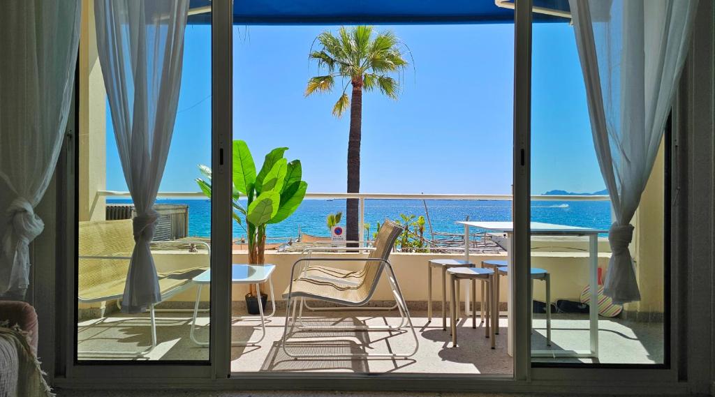un patio avec vue sur l'océan et une table et des chaises dans l'établissement Deux pièces cosy, front de mer, terrasse et 2 SdB, à Antibes