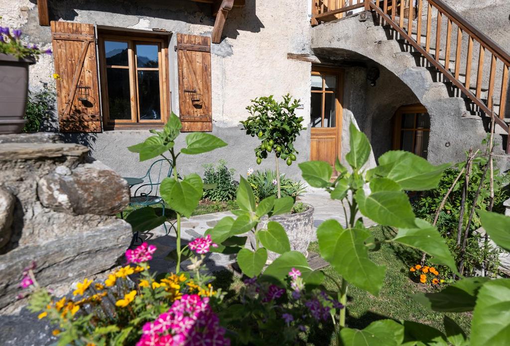 a garden in front of a house with flowers at Sweet Home 119 spa privé in Château-Ville-Vieille