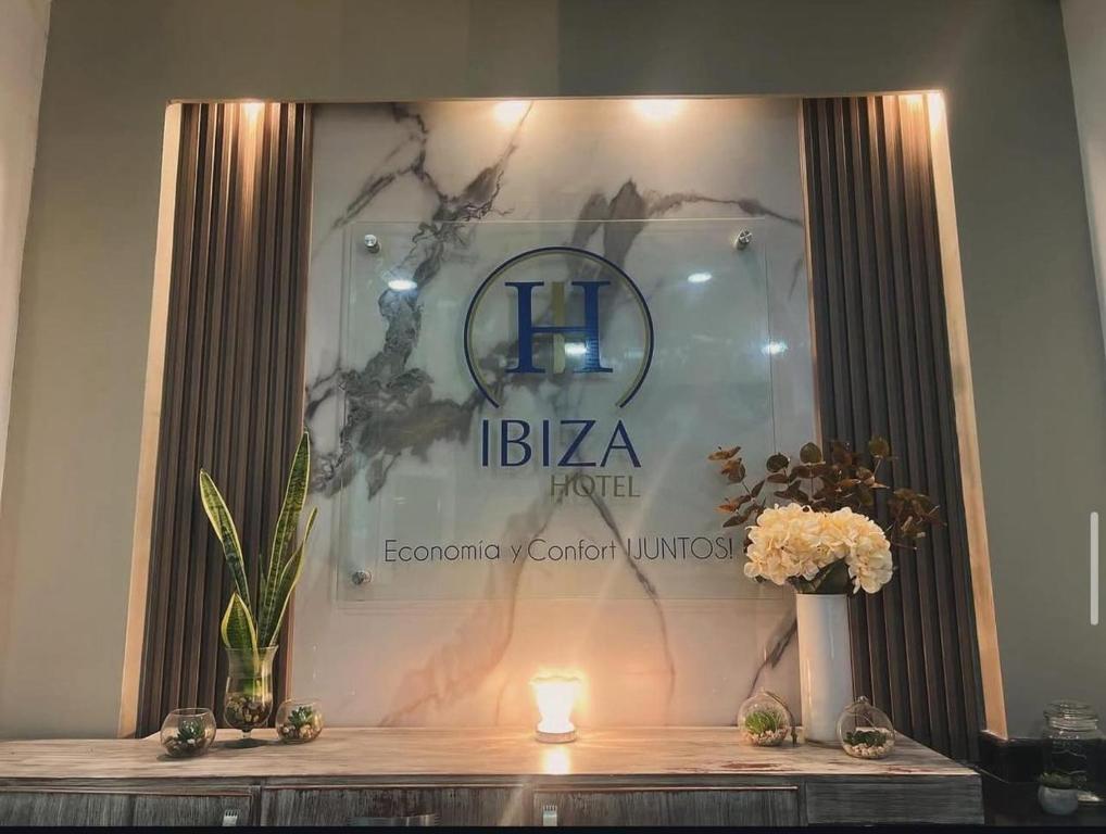 卡塔赫纳Hotel Ibiza Hotel en Cartagena de indias, sector comercial的桌子上有鲜花的酒店招牌