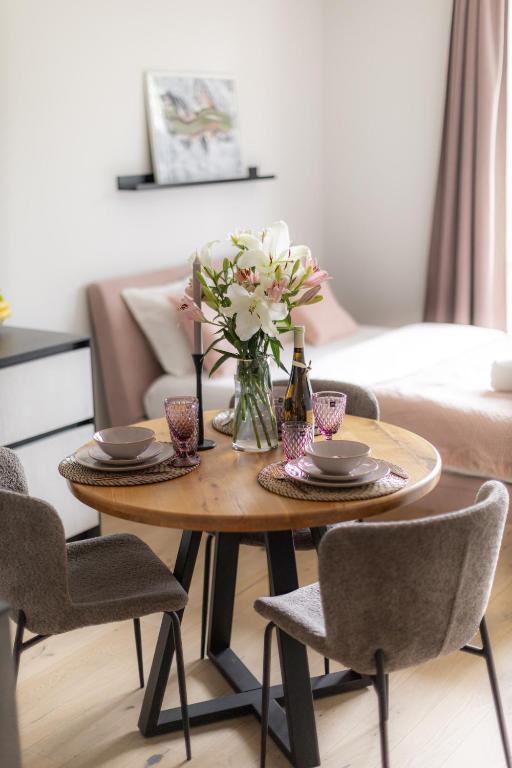 a coffee table with a vase of flowers on it at La Tereza Apartments in Ķesterciems
