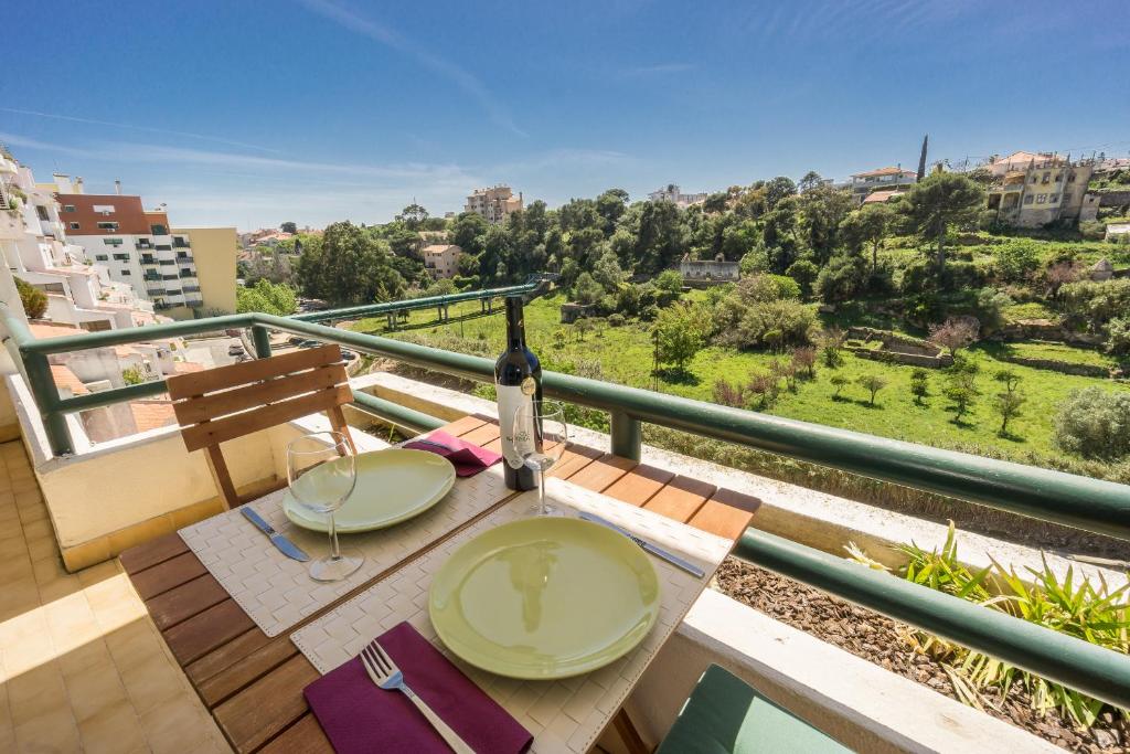 a table with a bottle of wine on a balcony at Farmers Market Vila Apartment in Cascais