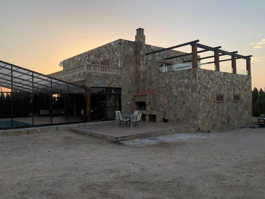 een stenen gebouw met twee stoelen ervoor bij Coparelia in Villarrobledo